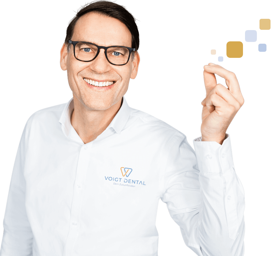 Zahnarzt von Voigt Dental lächelt freundlich und weist auf wichtige Informationen hin.